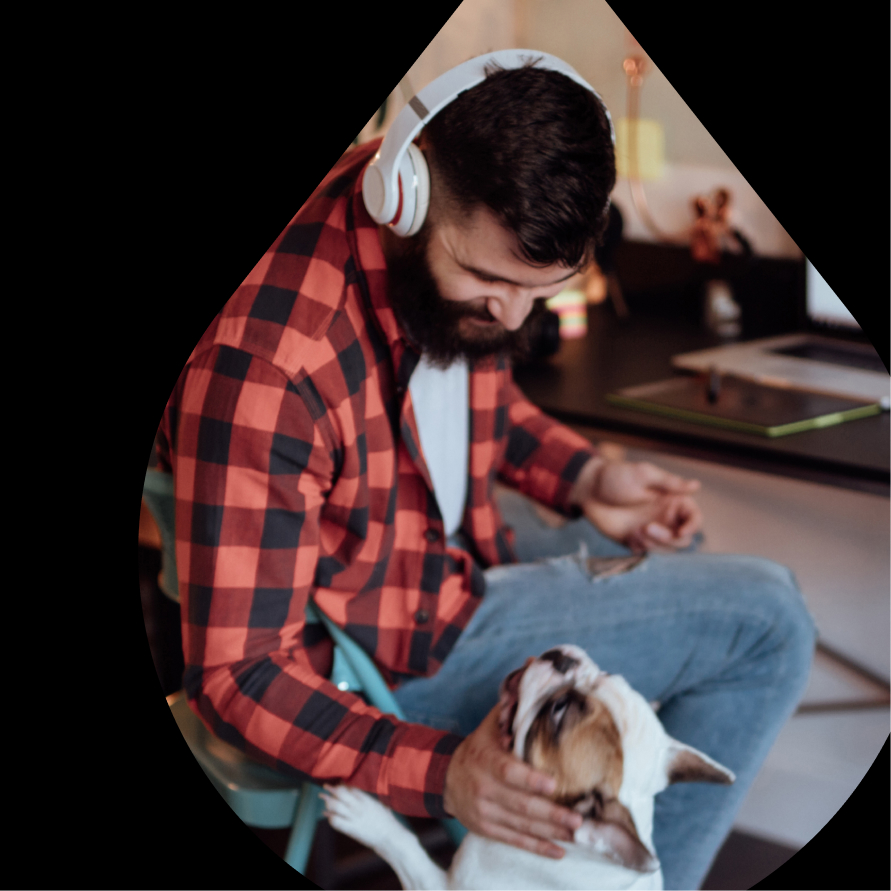 Man sitting in his office chair, petting his dog